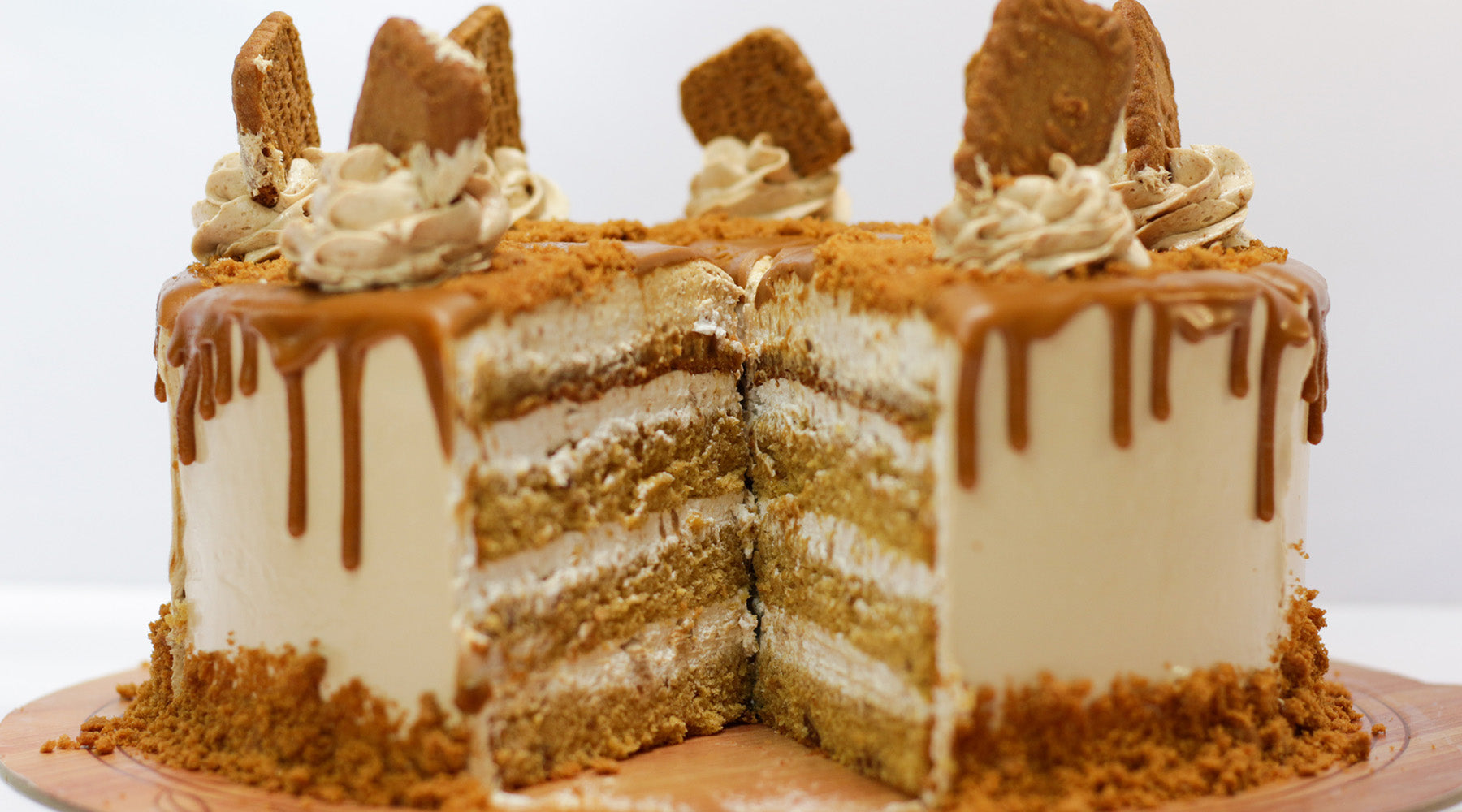 Cream colored cake topped with whipped cream and brown butter streusel running down the side