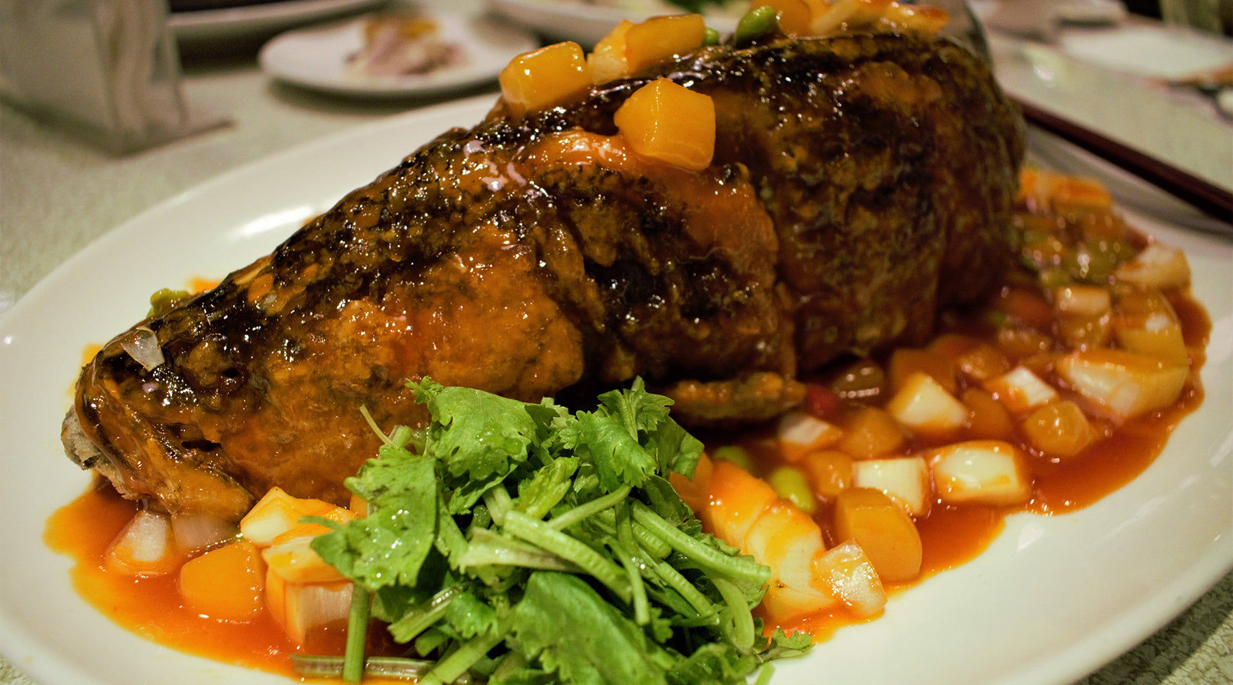 Barbeque pork topped with blistered chile-pumpkin seed salsa on a white plate