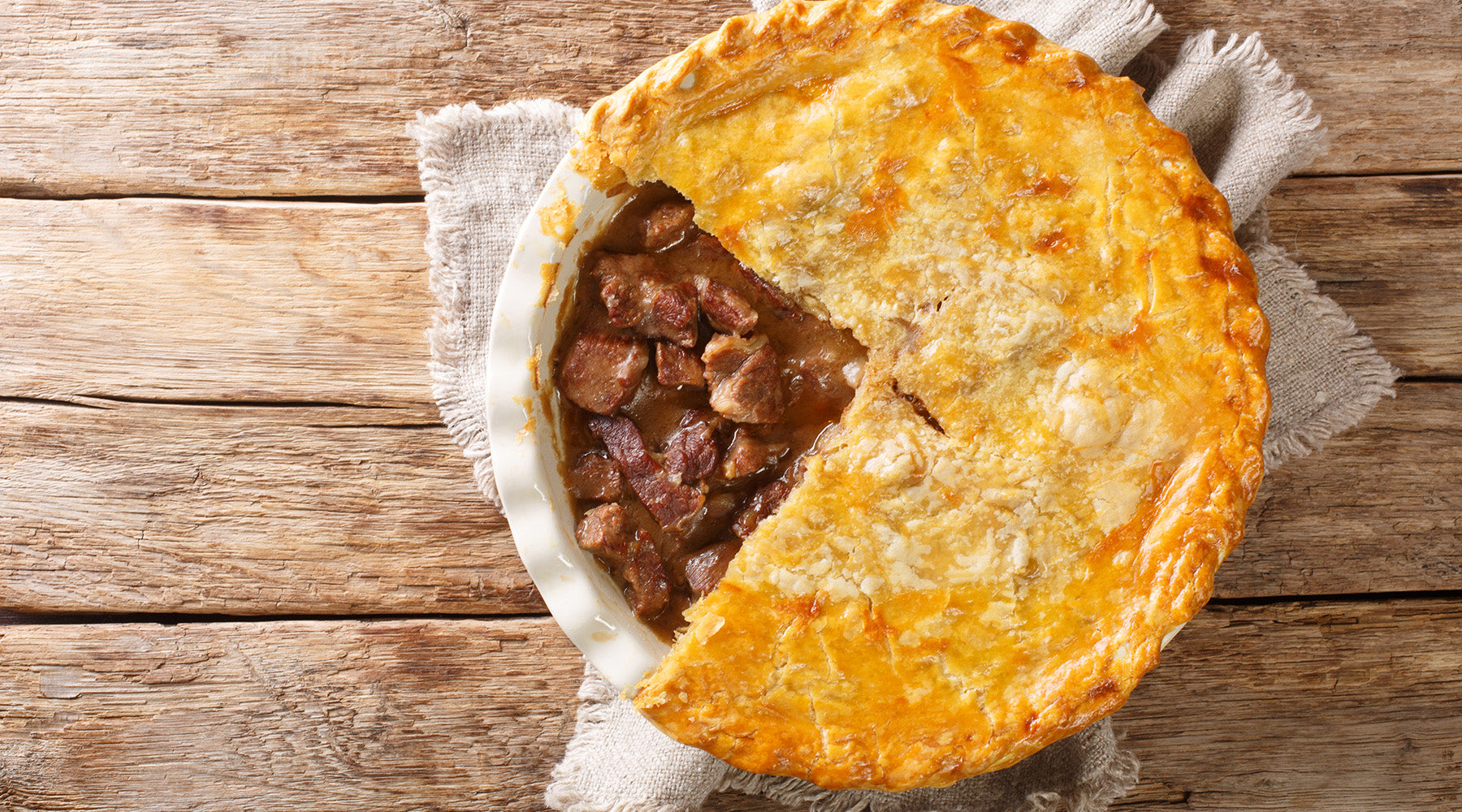 Beef Pie sitting on a wooden table