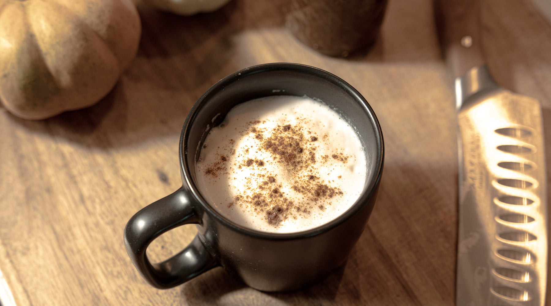 Pumpkin Spice Latte sitting on a cutting board with pumpkins