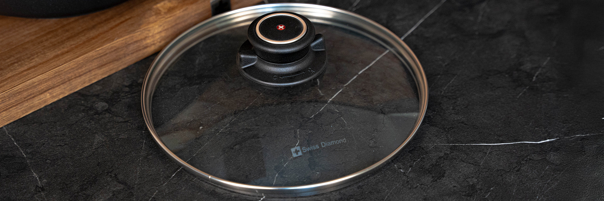 tempered glass lid next to a cutting board on a marble kitchen counter