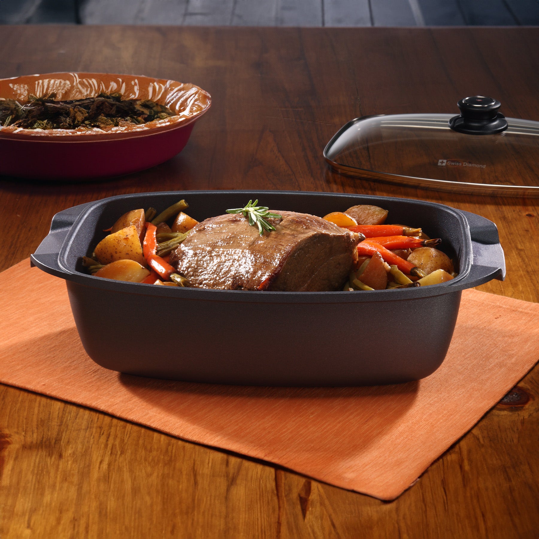 HD Nonstick 5.3 qt Roaster with Glass Lid in use on wooden dining room table