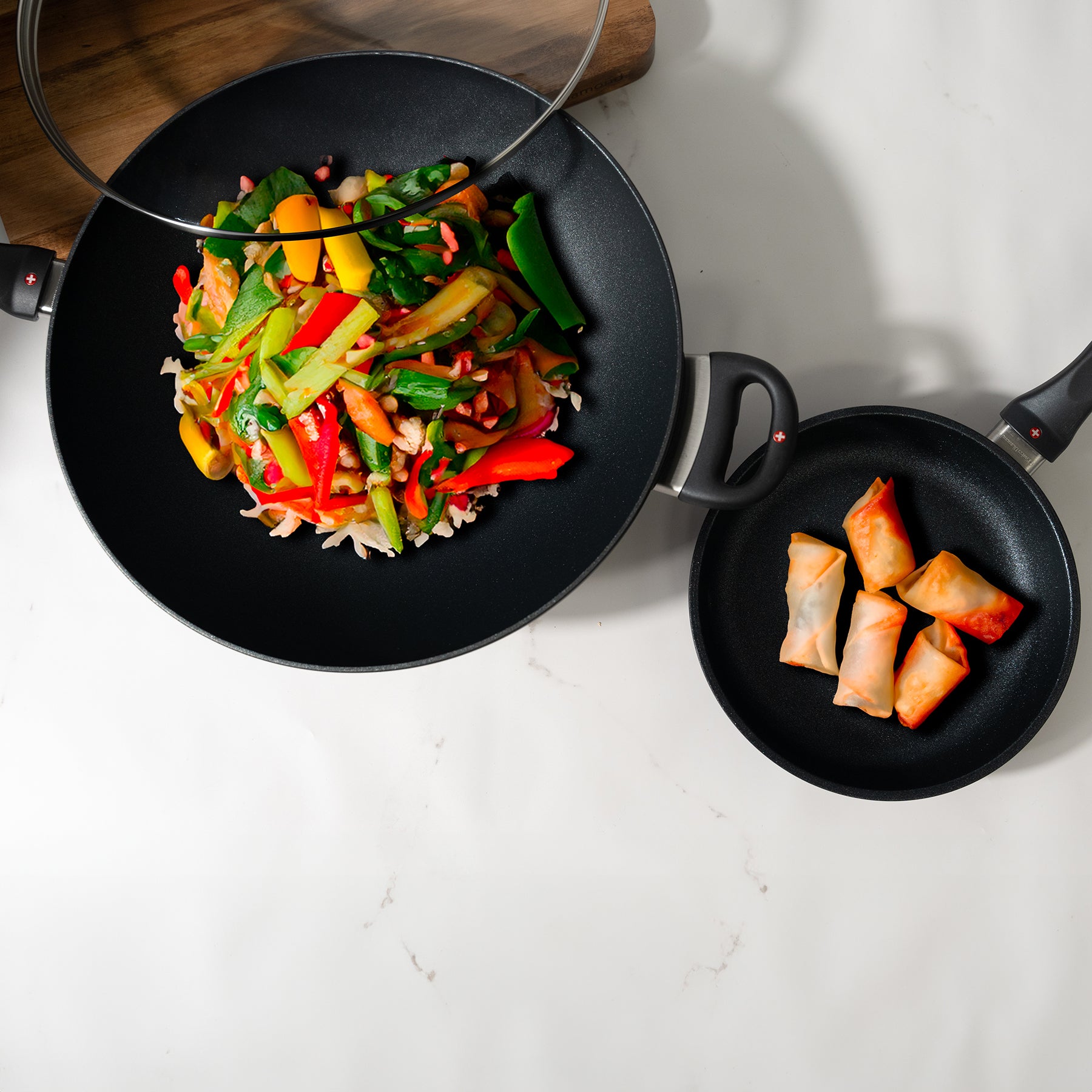 XD Nonstick 8" Fry Pan and 12.5" Wok with Glass Lid Set with food inside on a marble kitchen countertop