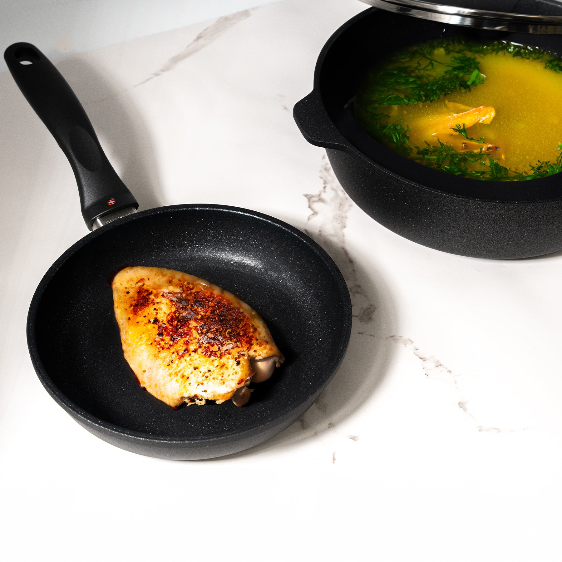 XD Nonstick 8" Fry Pan and 3.8 qt Saute Pan with Glass Lid Set in use with food on surface of pan sitting on kitchen pan