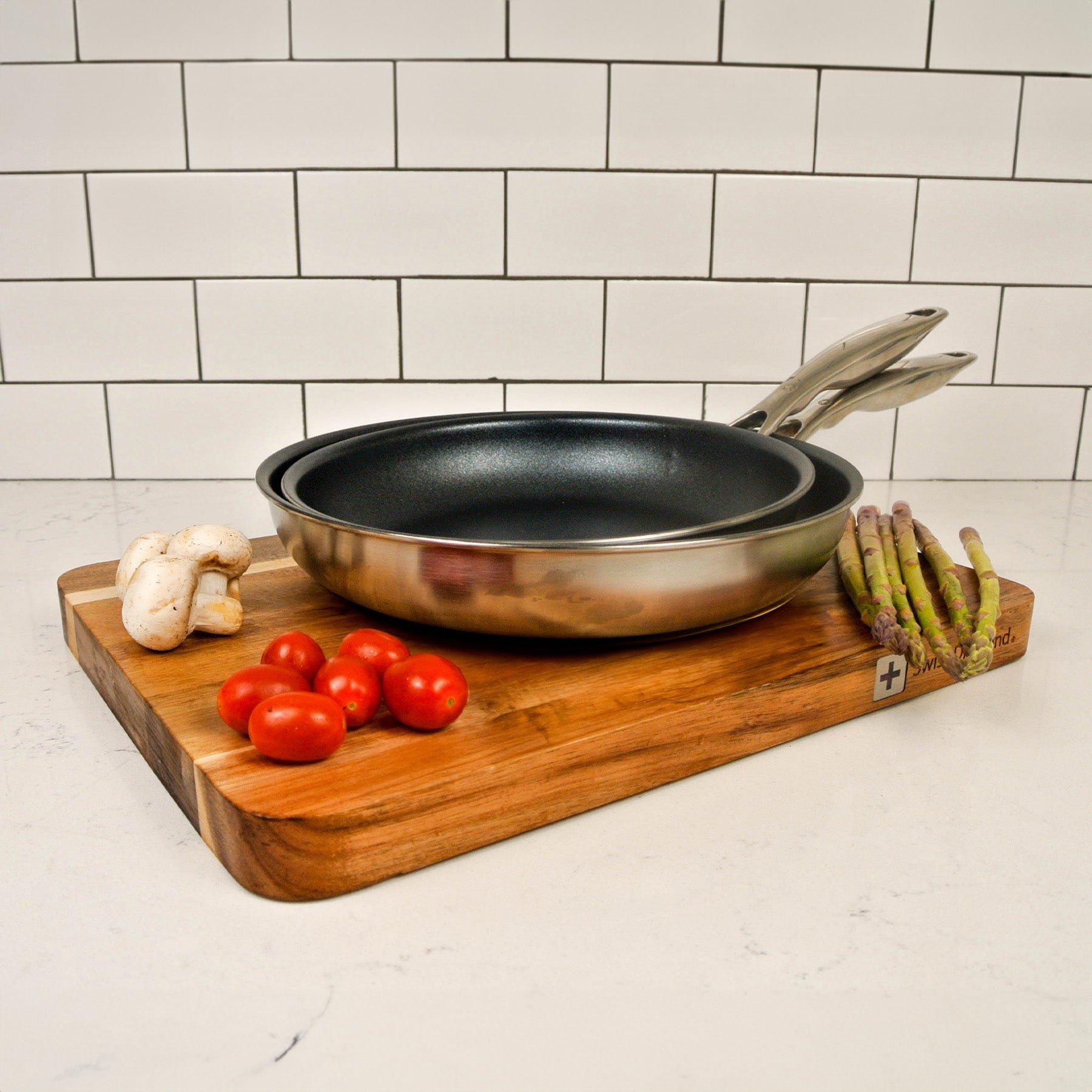Nonstick Clad Fry Pan 2-Piece Set - Induction in use on a cutting board on kitchen counter