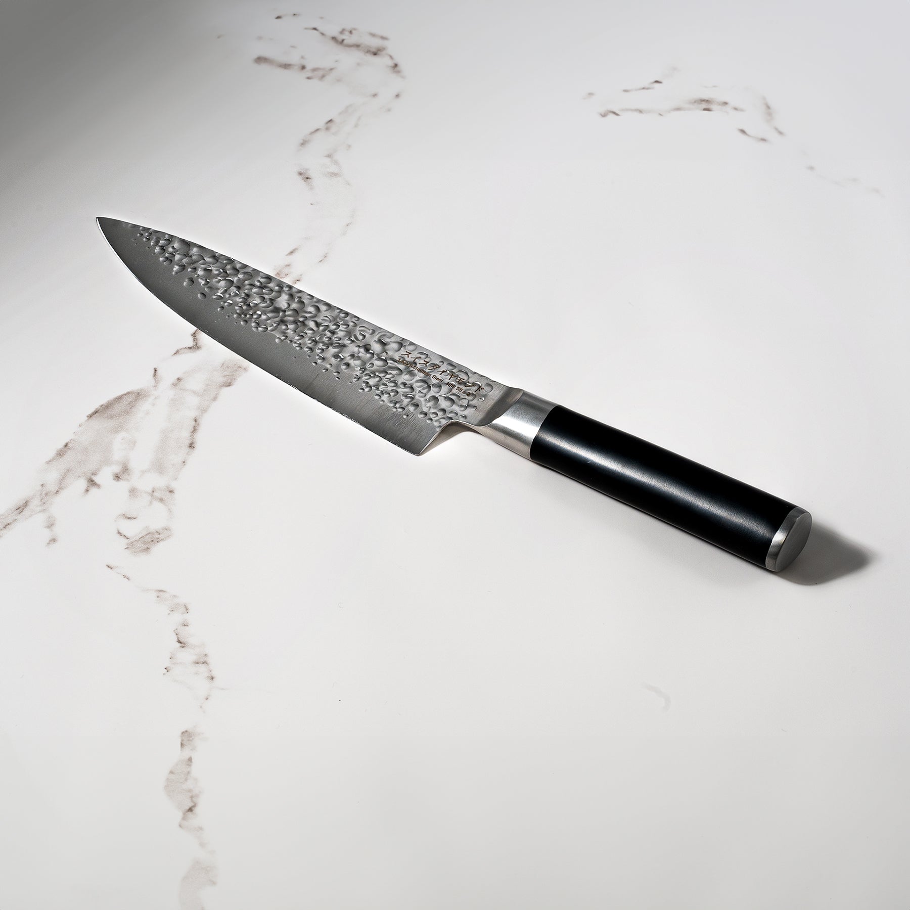 8" Hammered Chef Knife on white marble kitchen counter top