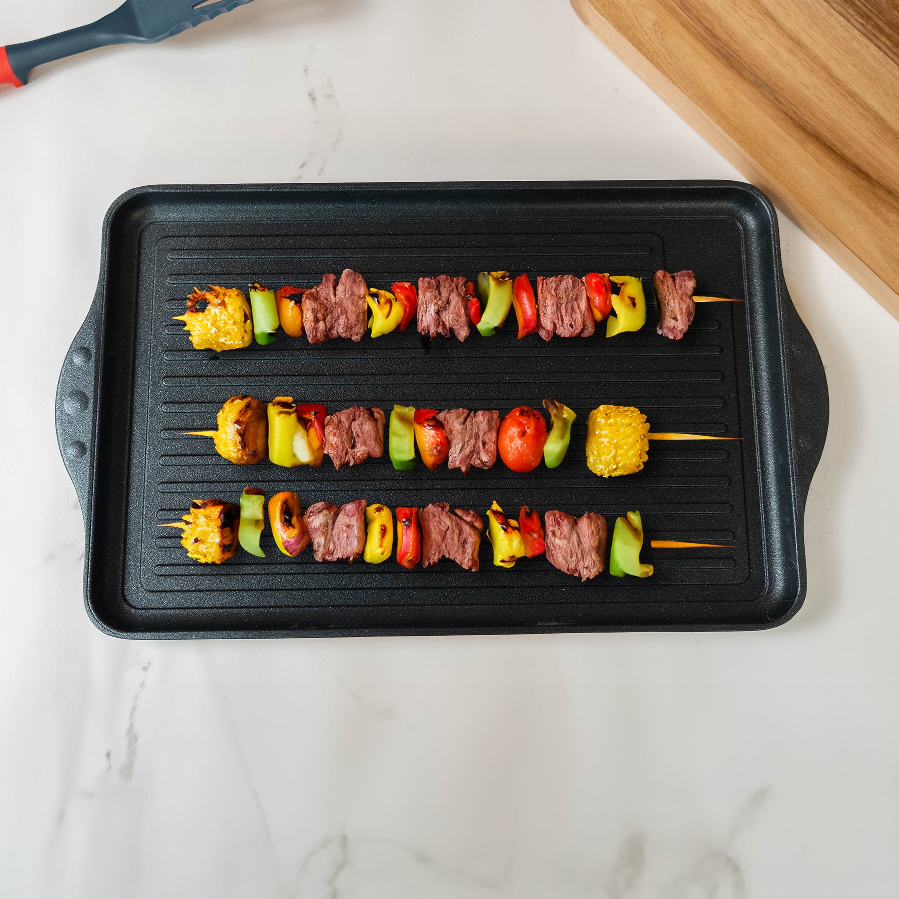 XD Nonstick 17" x 11" Double-Burner Grill in use with food on pan