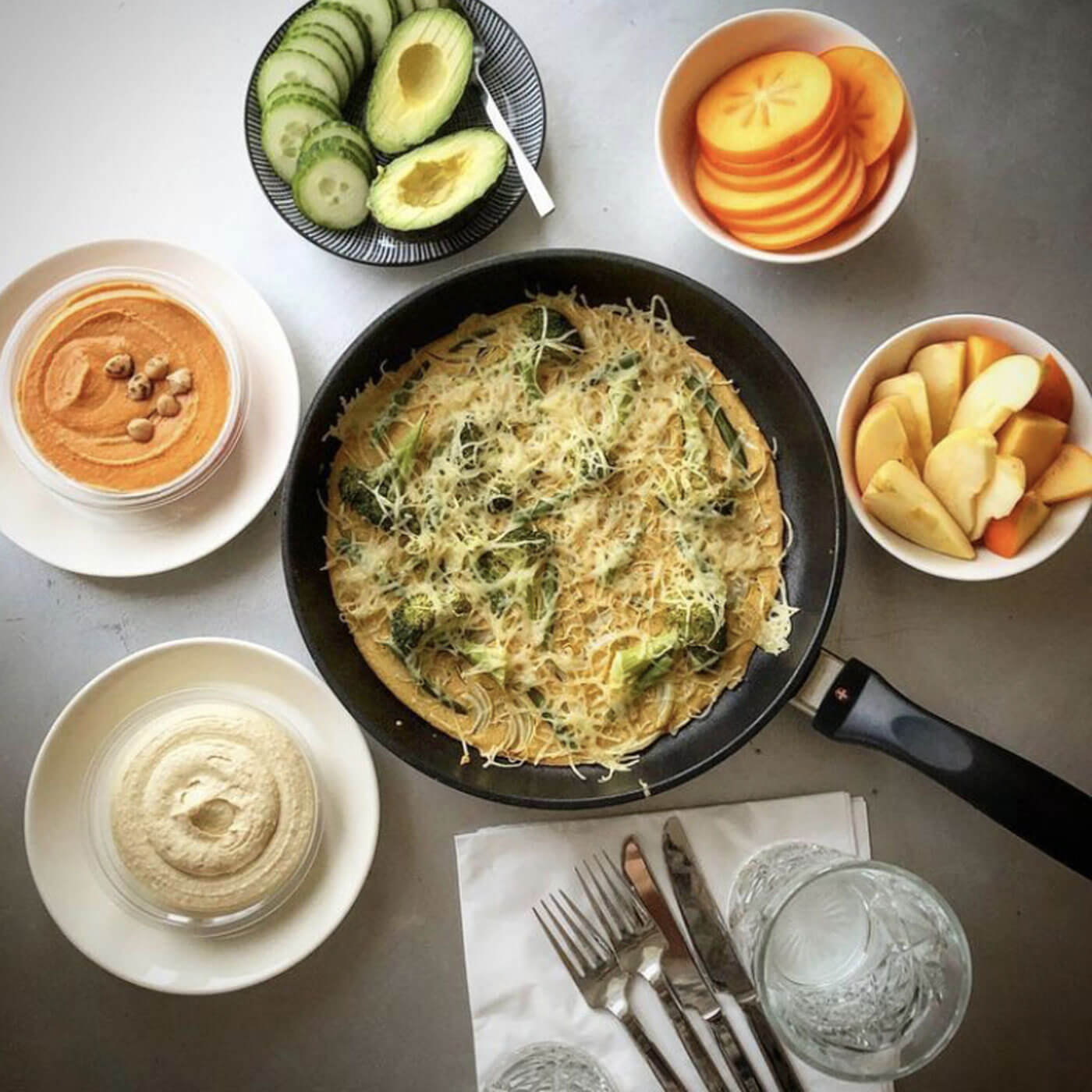 xd fry pan in use with sauce, cooked veggies, and side dishes on table