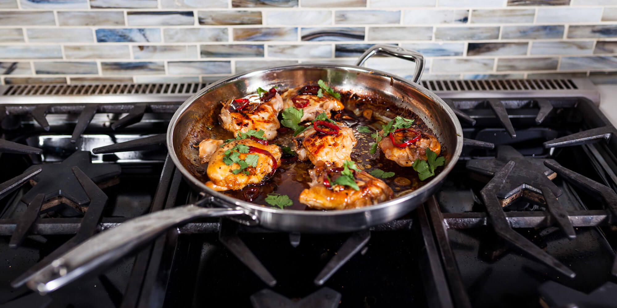 dlx fry pan with food inside sitting on gas grill stock top burner