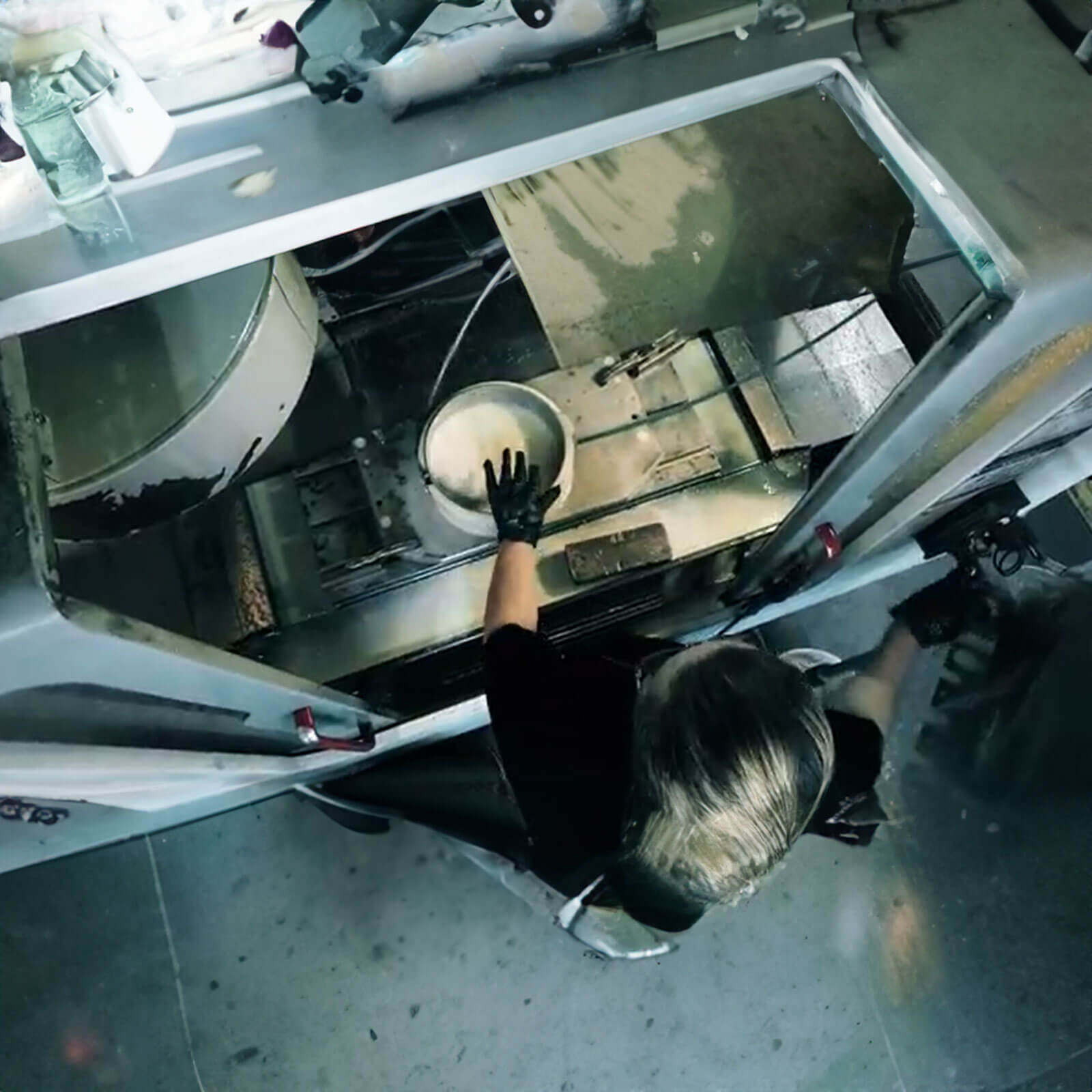 factory worker handling a fry pan being washed and coated