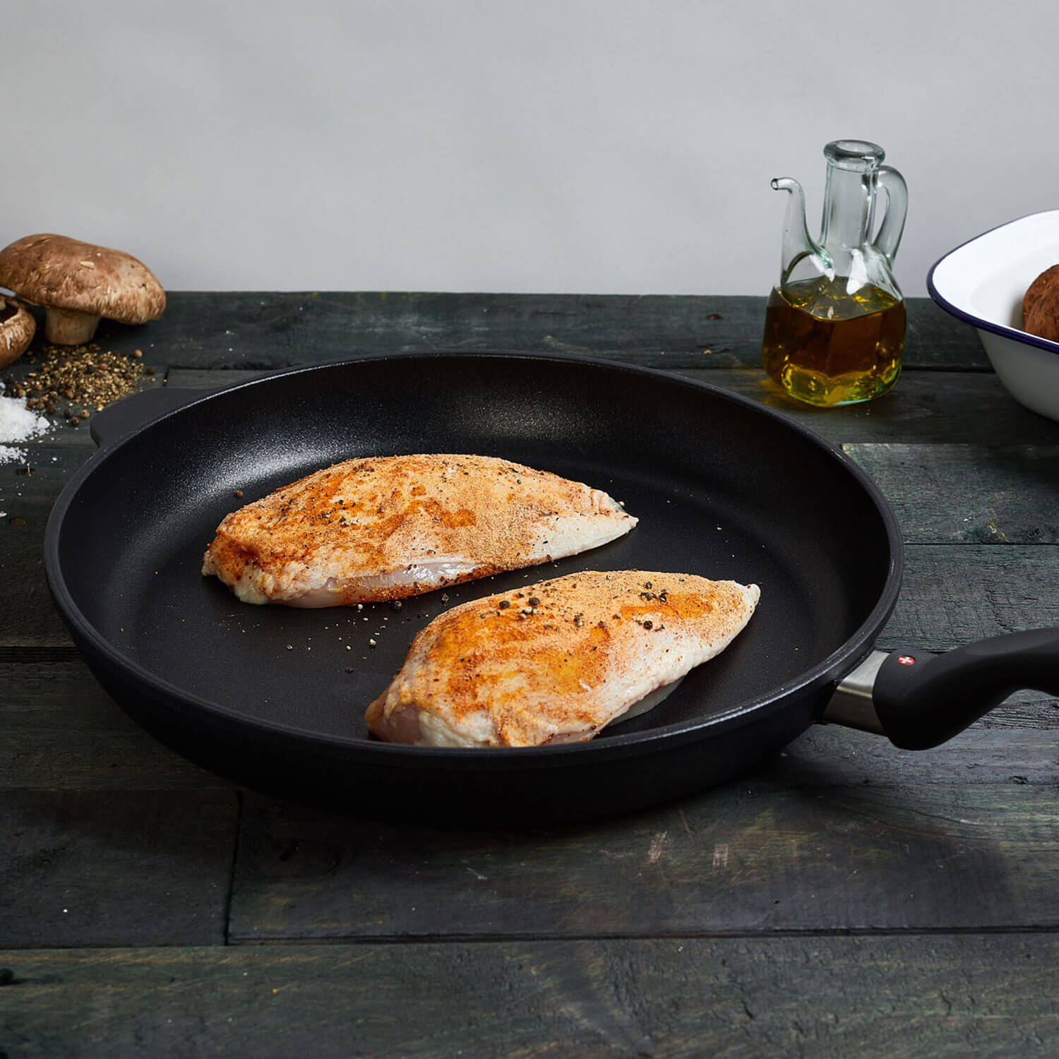 xd fry pan in use with cooked chicken breast on a wooden table