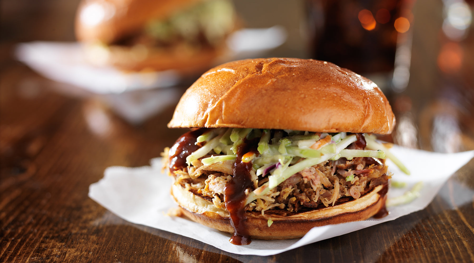Pulled pork topped with apple slaw in a sandwich 