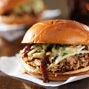 Pulled pork topped with apple slaw in a sandwich 