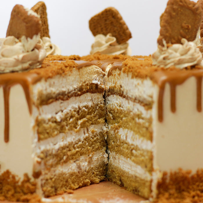 Cream colored cake topped with whipped cream and brown butter streusel running down the side 
