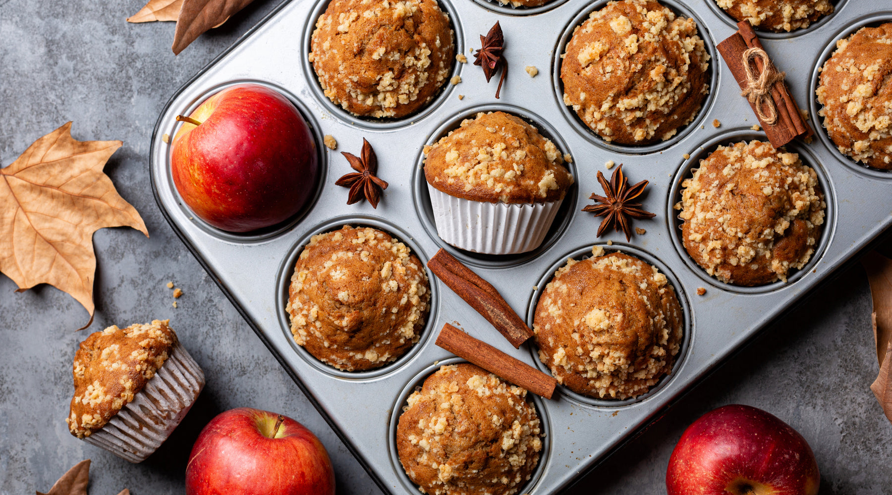 Apple Oatmeal Muffins in a muffin pan surrounded by fall elements