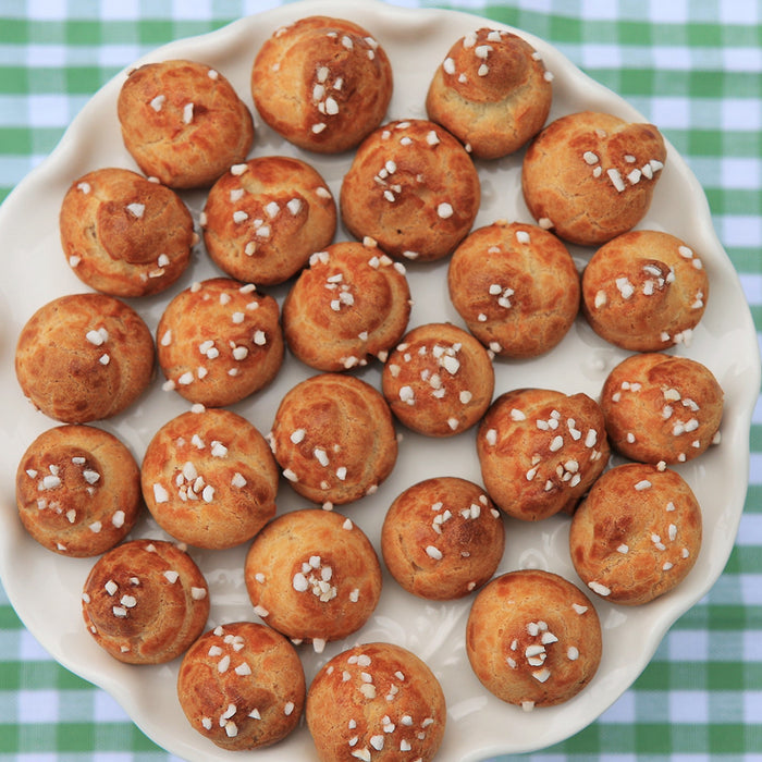 pretzel bites on a plate and a glass of beer to the left of the plate