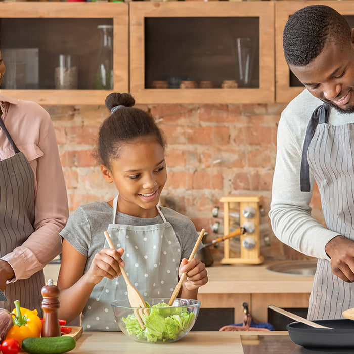 family of 3 cooking together in a kitchen