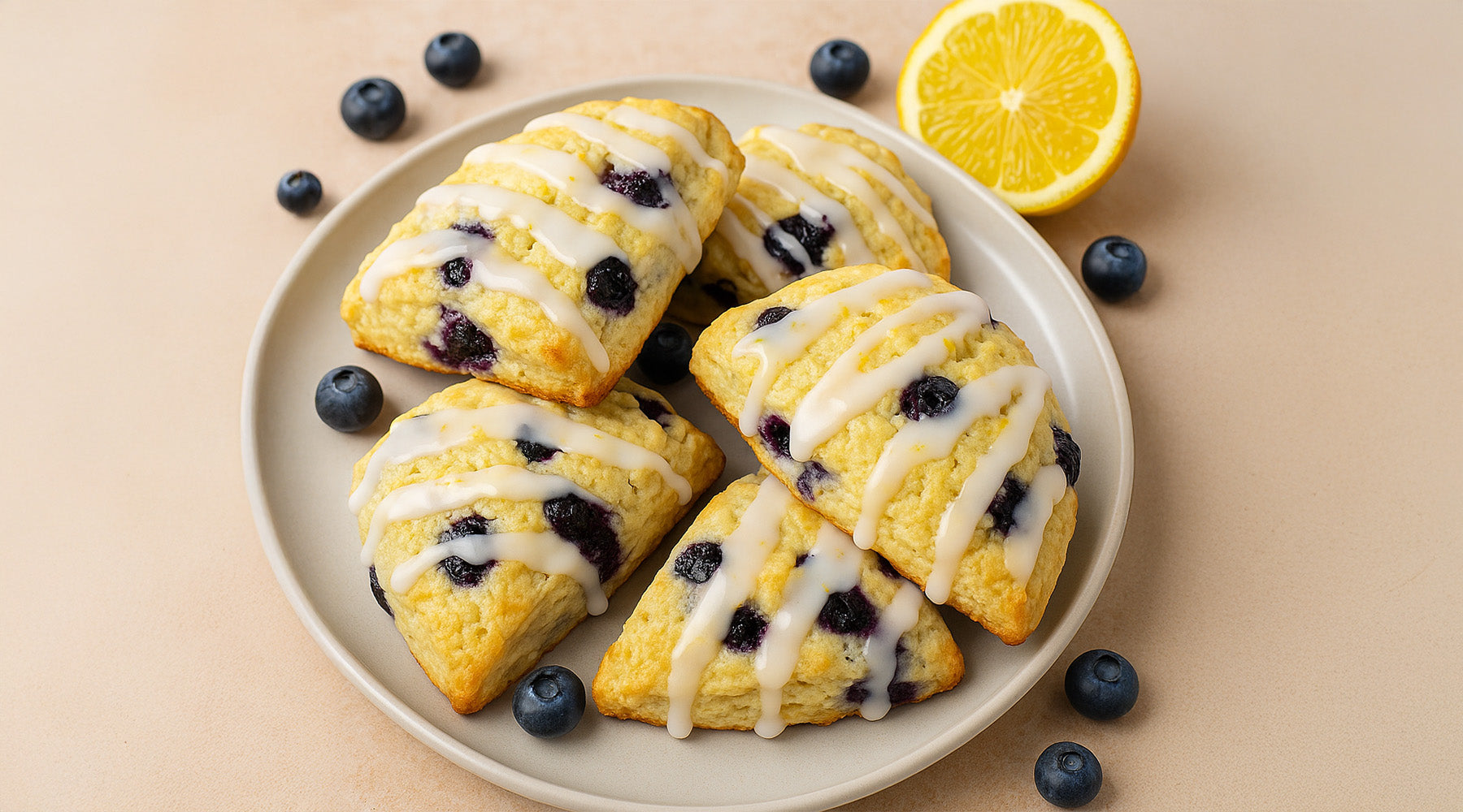 Lemon Blueberry Scones on a white plate with blueberries scattered around