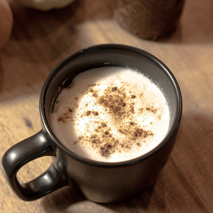 Pumpkin Spice Latte sitting on a cutting board with pumpkins