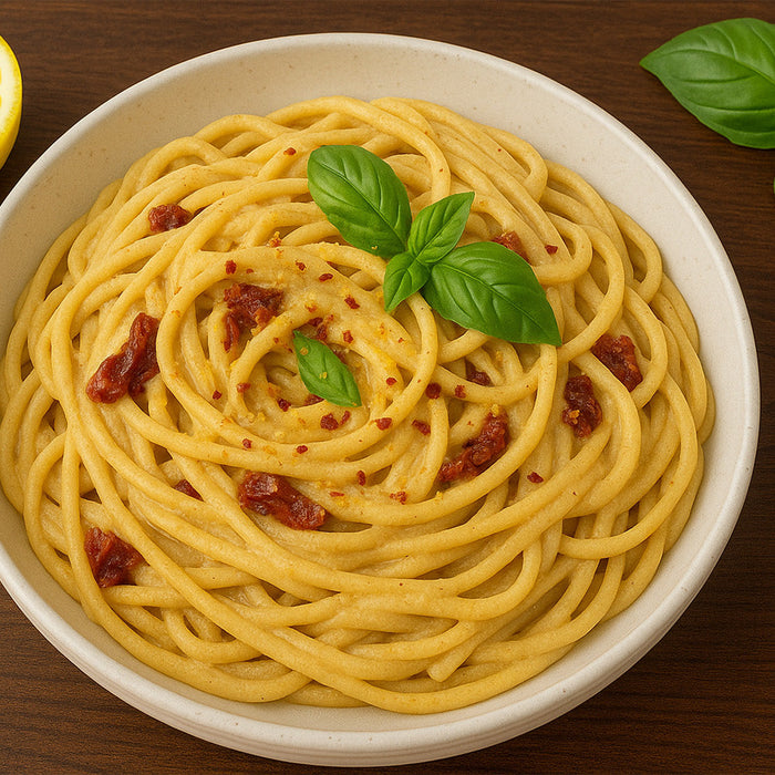 Tahini Sun-Dried Tomato Pasta in a white bowl on a wood tabletop
