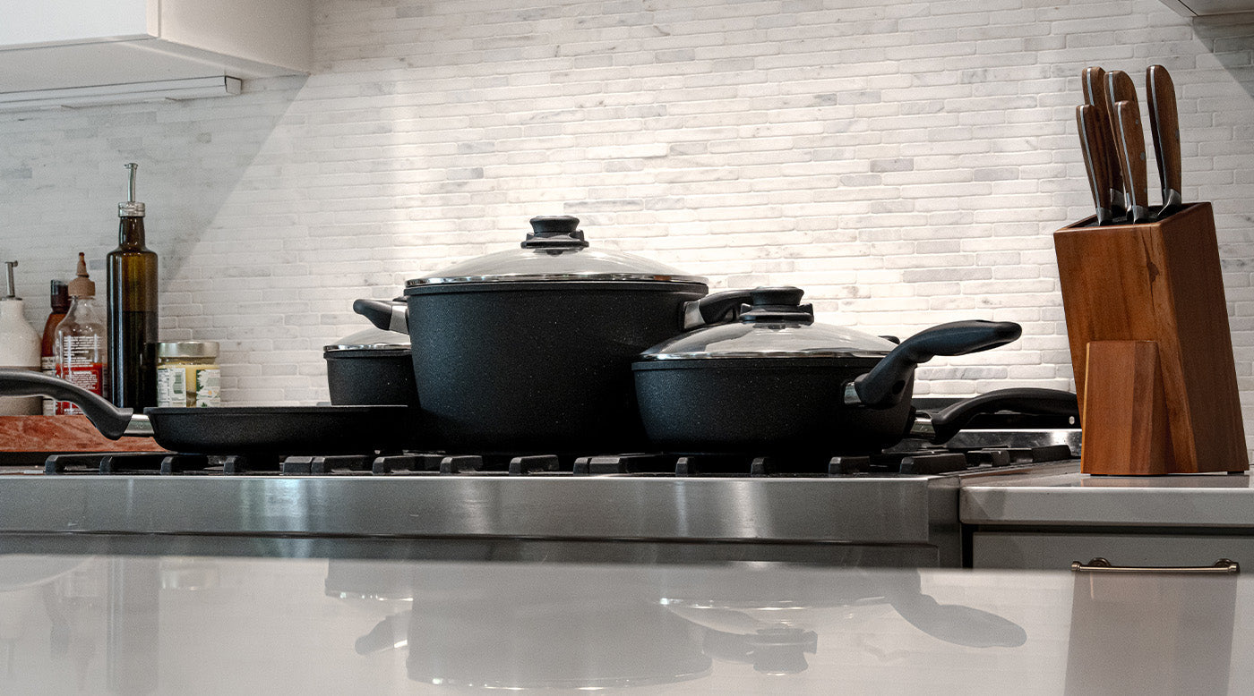 closeout sale cookware including fry pans, saute pans, stock pots on kitchen stove top