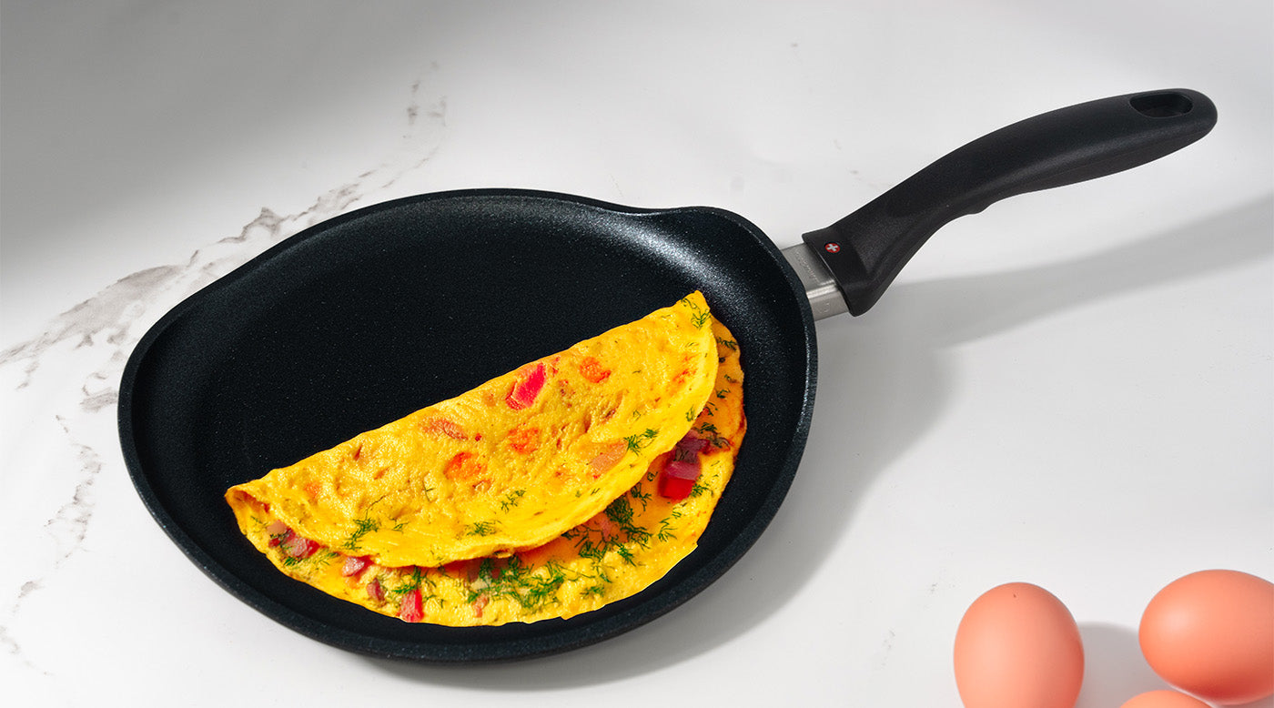 Nonstick Specialty Pots & Pans with food inside on a while marble kitchen counter