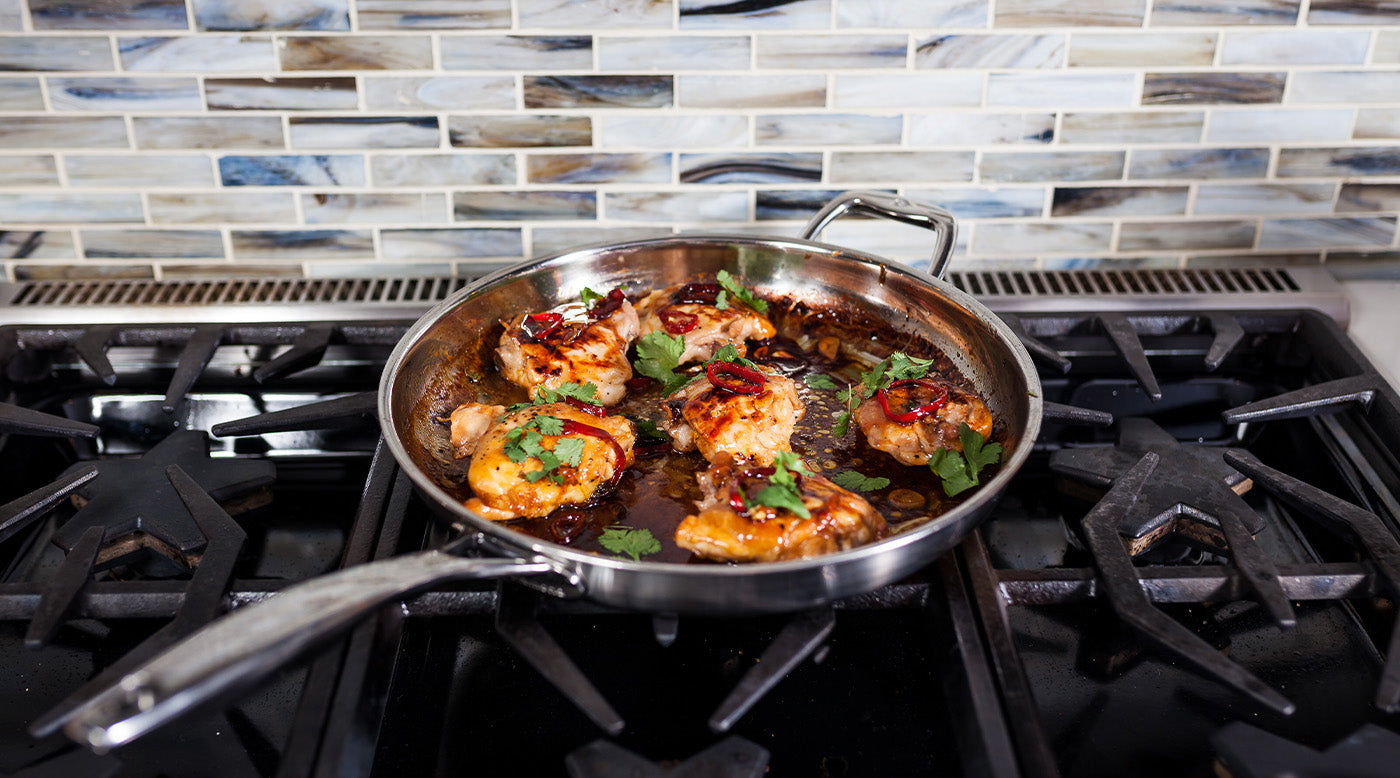 Premium Clad with food inside on gas stove top