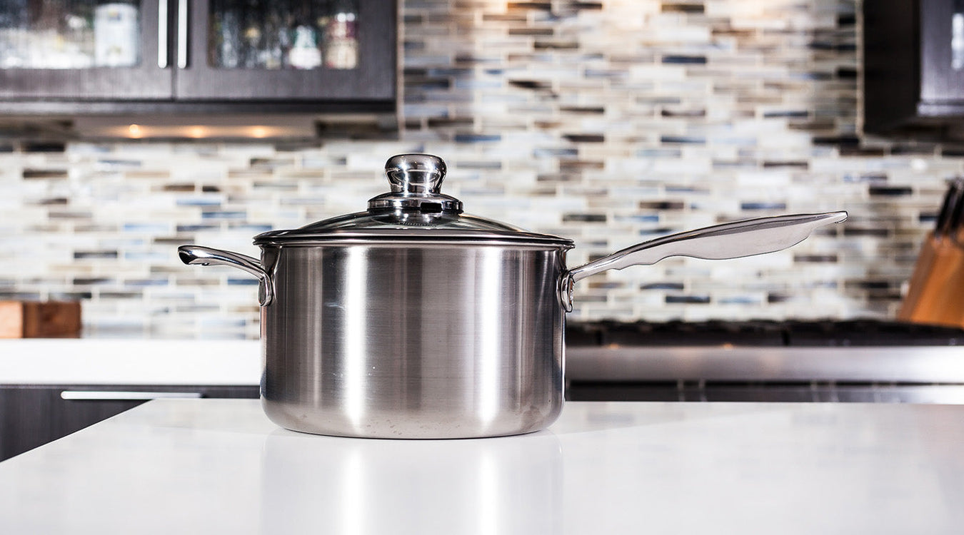Stainless Steel Saucepan & Sauce Pots with glass lid side profile view on white marble kitchen counter