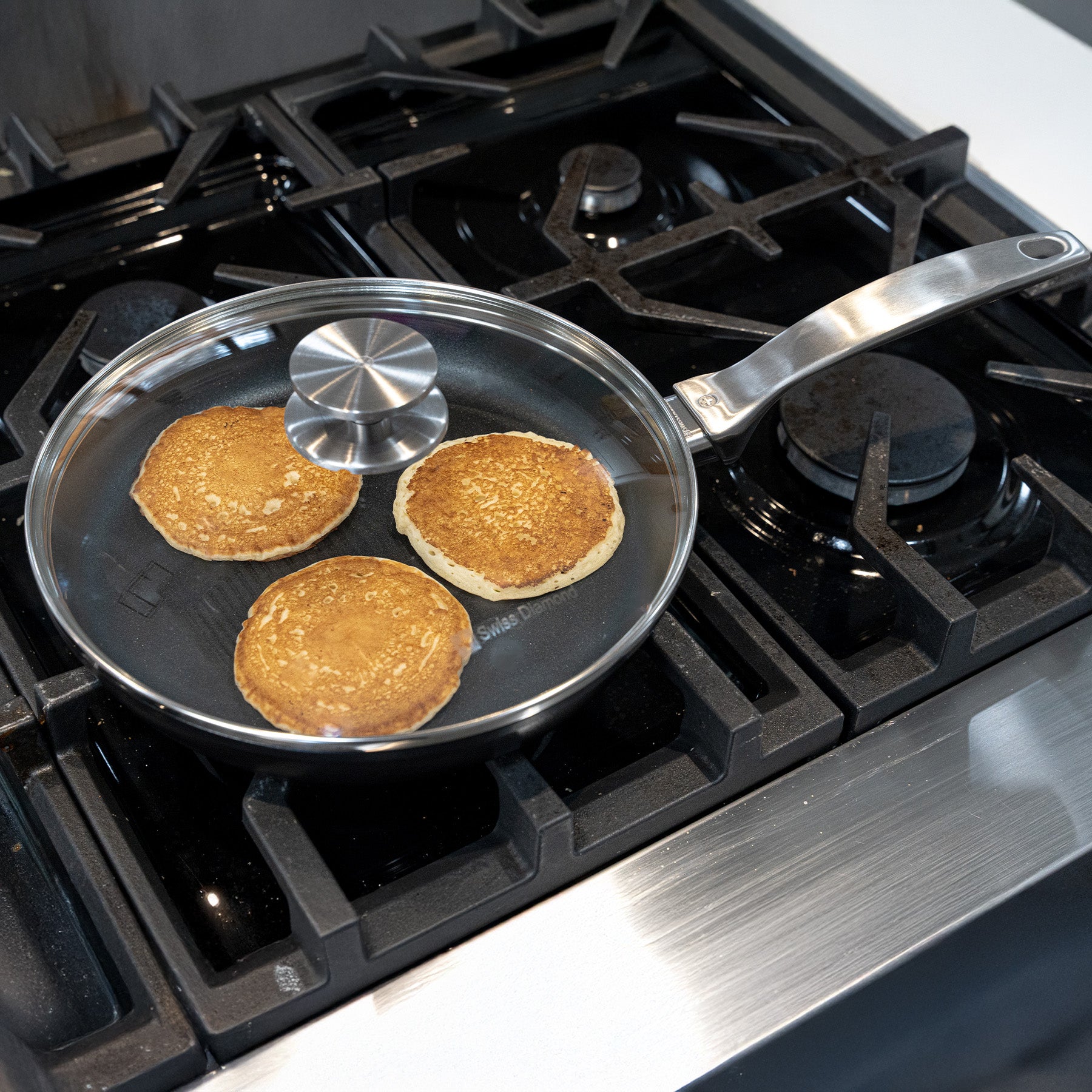 CHD Nonstick 9.5" Fry Pan with Glass Lid on gas stove with food inside