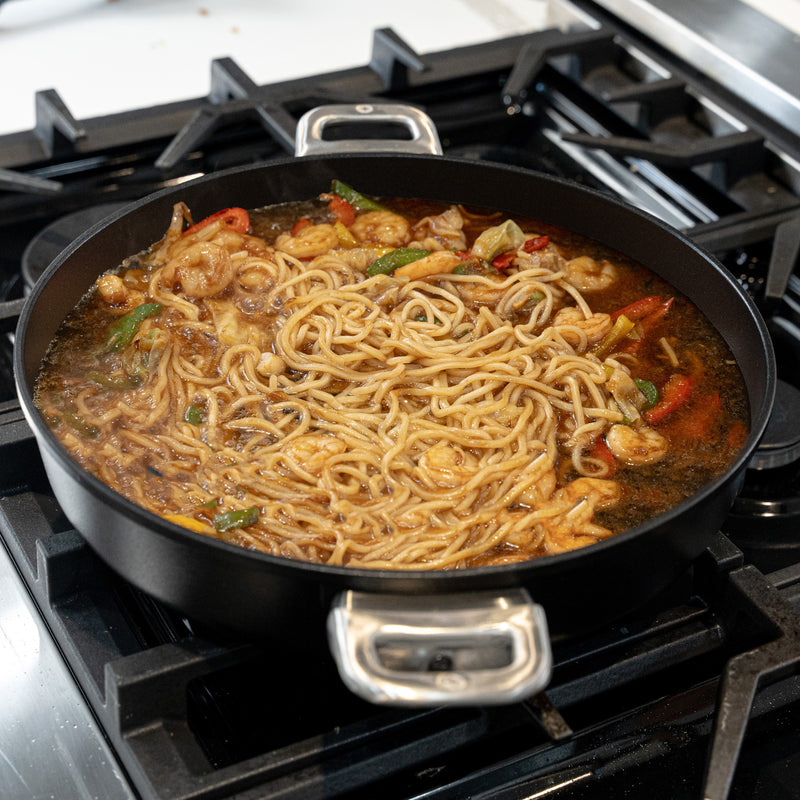 CHD Nonstick 4.8 qt Sauteuse with Glass Lid on gas stove top with food inside