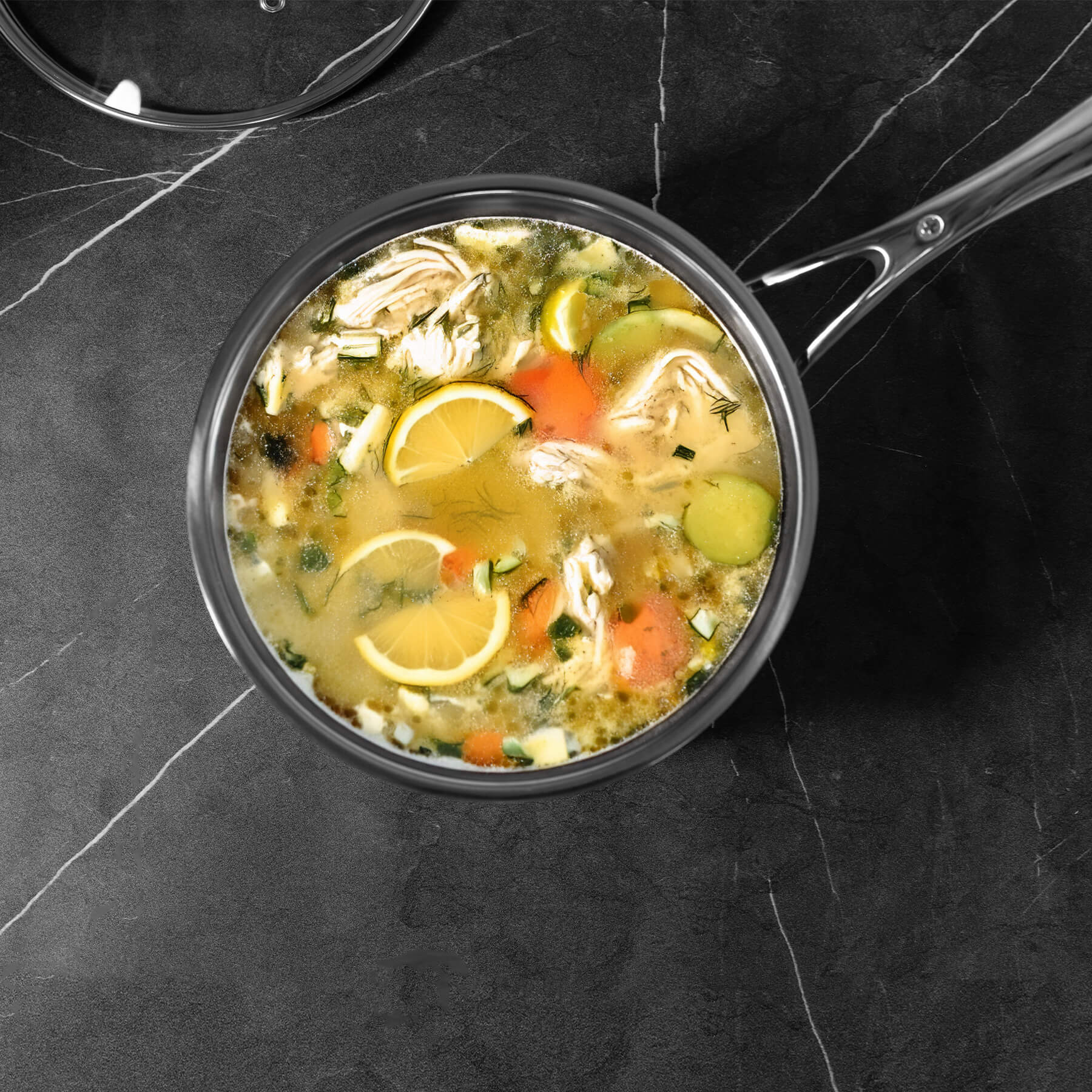 Premium Steel DLX Saucepan with Glass Lid - Induction in use with food inside on a kitchen counter
