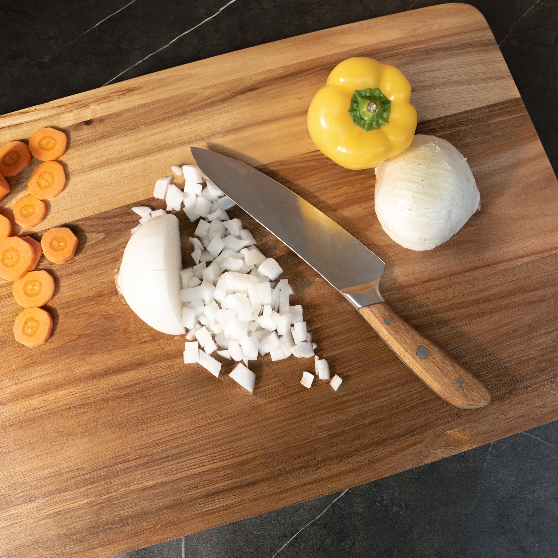 24" Acacia Wood Cutting Board with a view from top in use food being chopped on surface