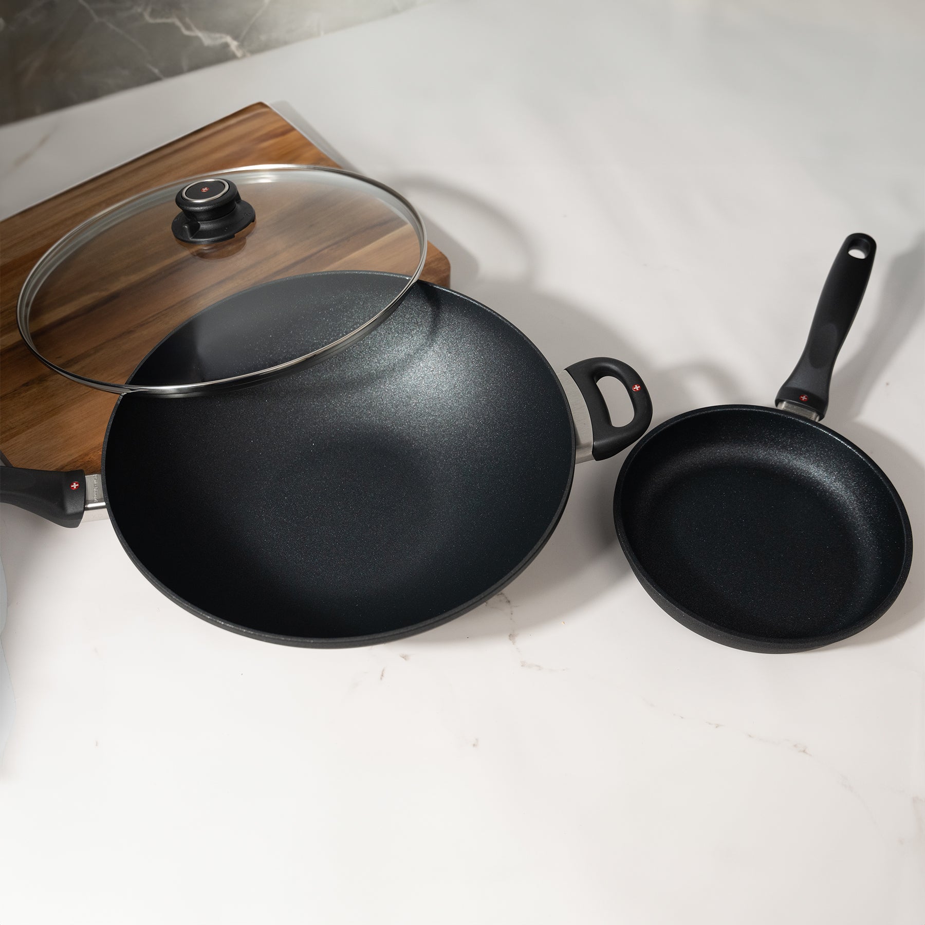 XD Nonstick 8" Fry Pan and 12.5" Wok with Glass Lid Set on kitchen counter with cutting board next to it