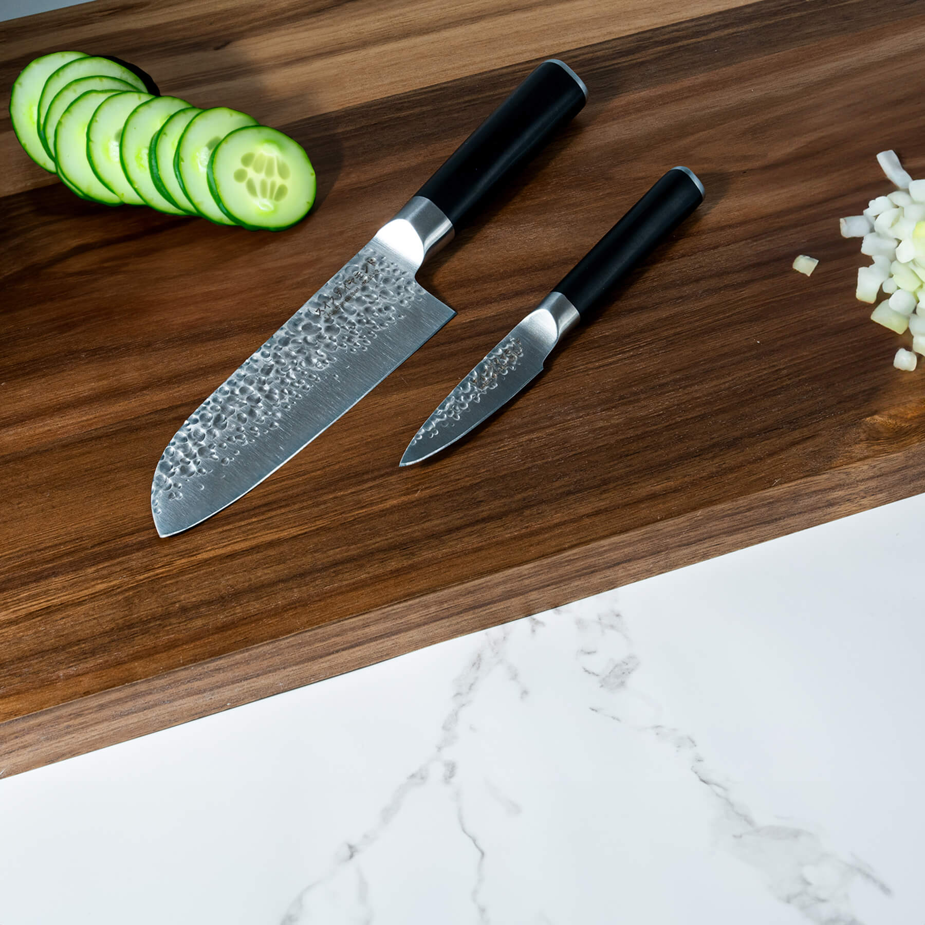 Hammered Santoku Paring Set on wooden cutting board with food