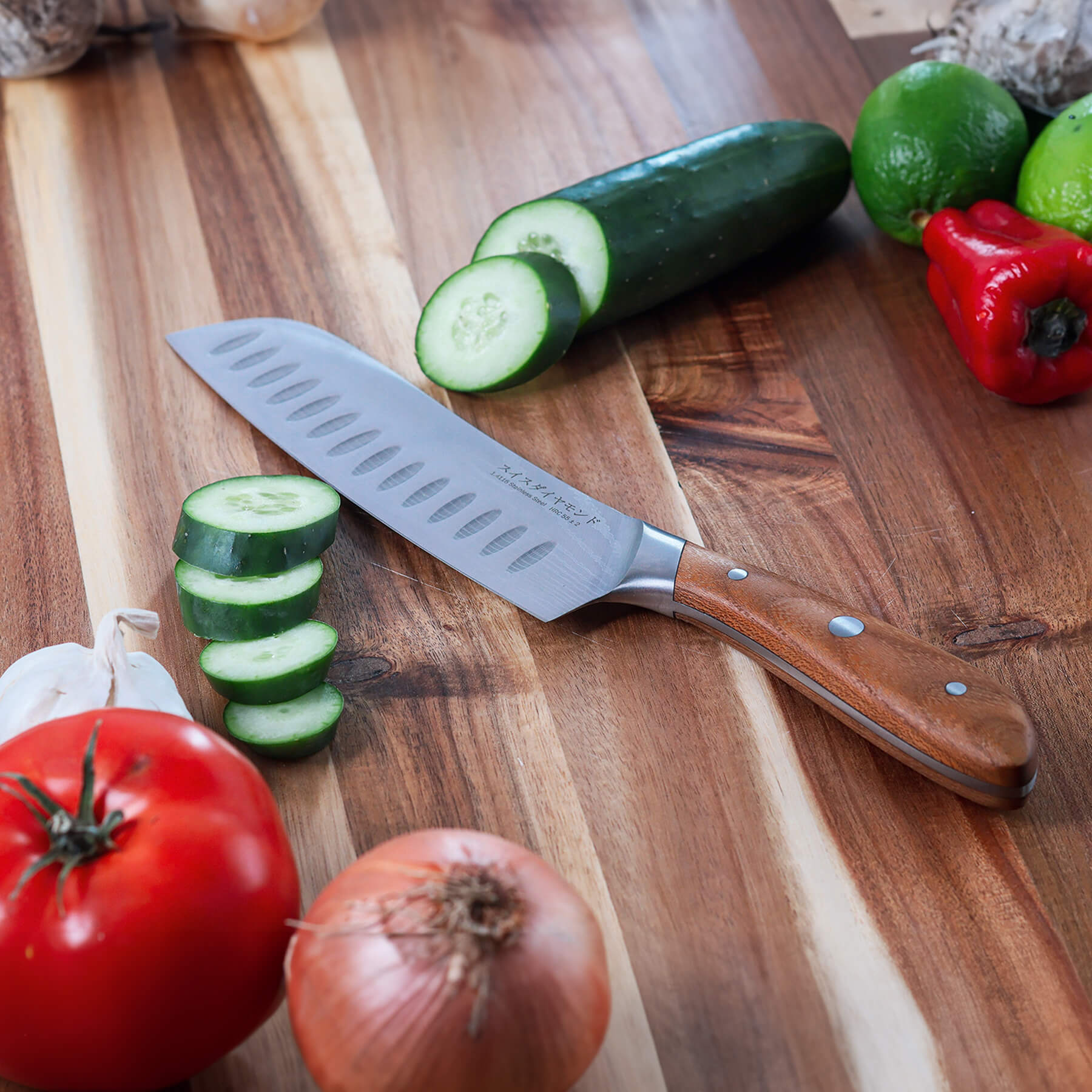 7" Damascus Santoku Knife on cutting board with sliced cucumbers and other vegetables 