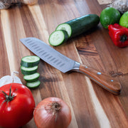 7" Damascus Santoku Knife on cutting board with sliced cucumbers and other vegetables