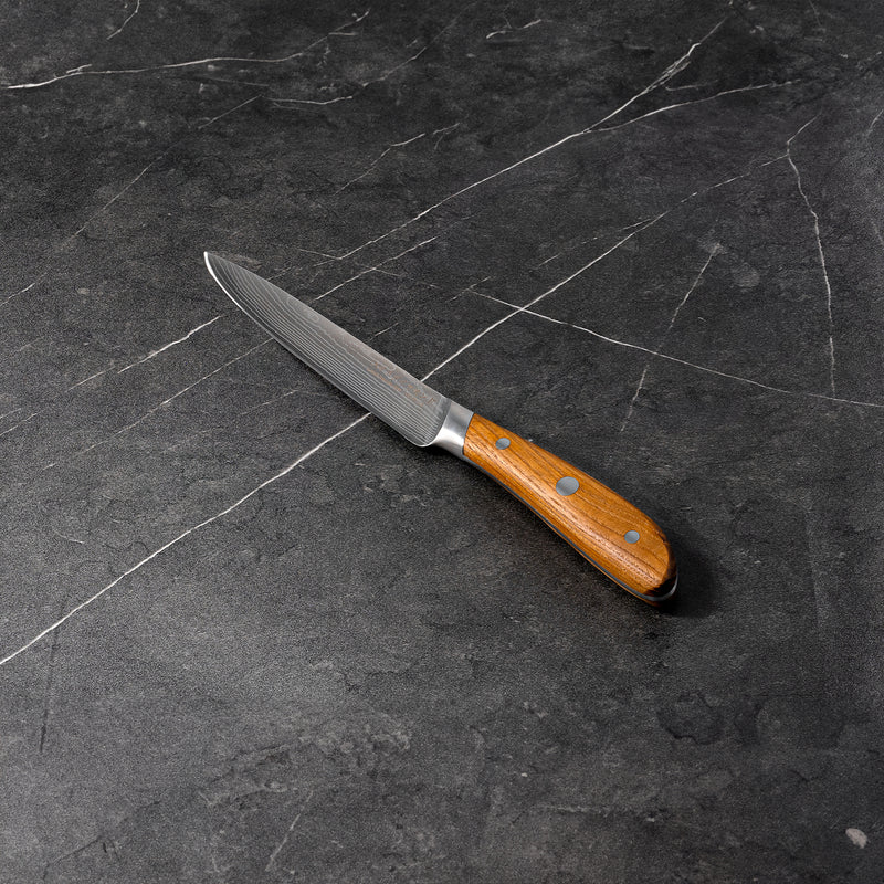 5" Damascus Utility Knife angled view on black marble kitchen counter top