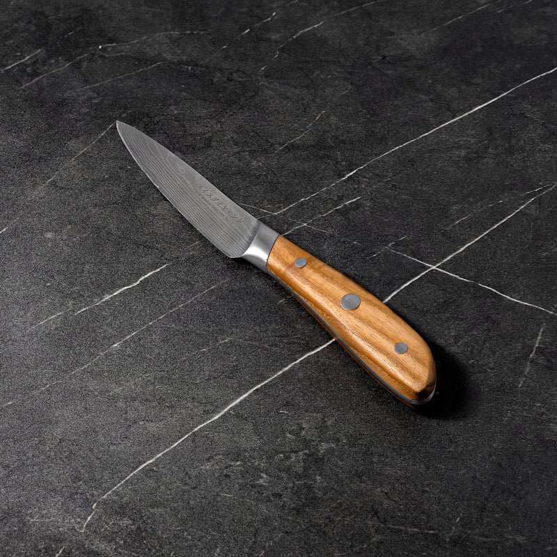 4" Damascus Paring Knife angled view on black marble counter top