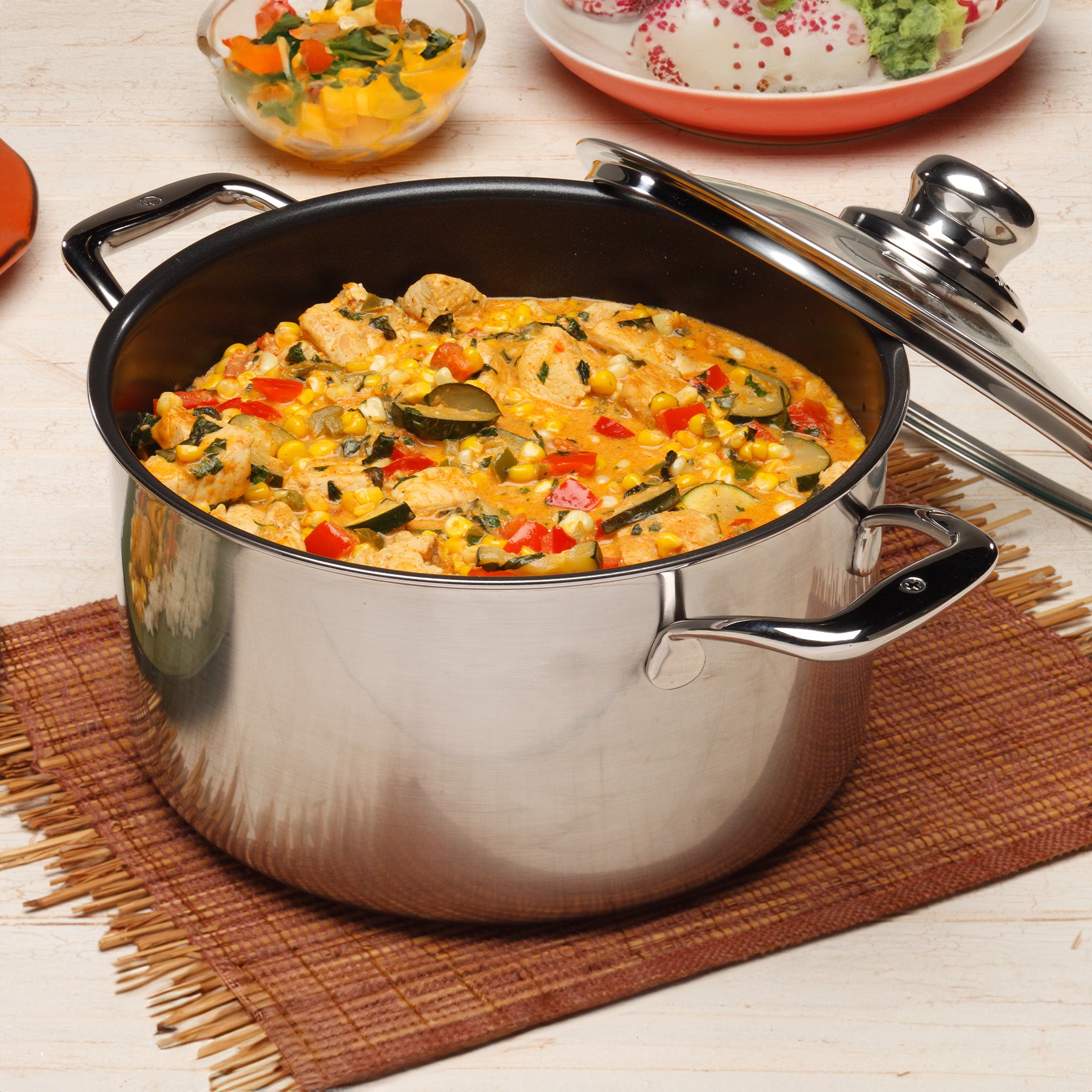 Nonstick Clad 6.3 qt Dutch Oven with Glass Lid - Induction in use on wooden dining room table