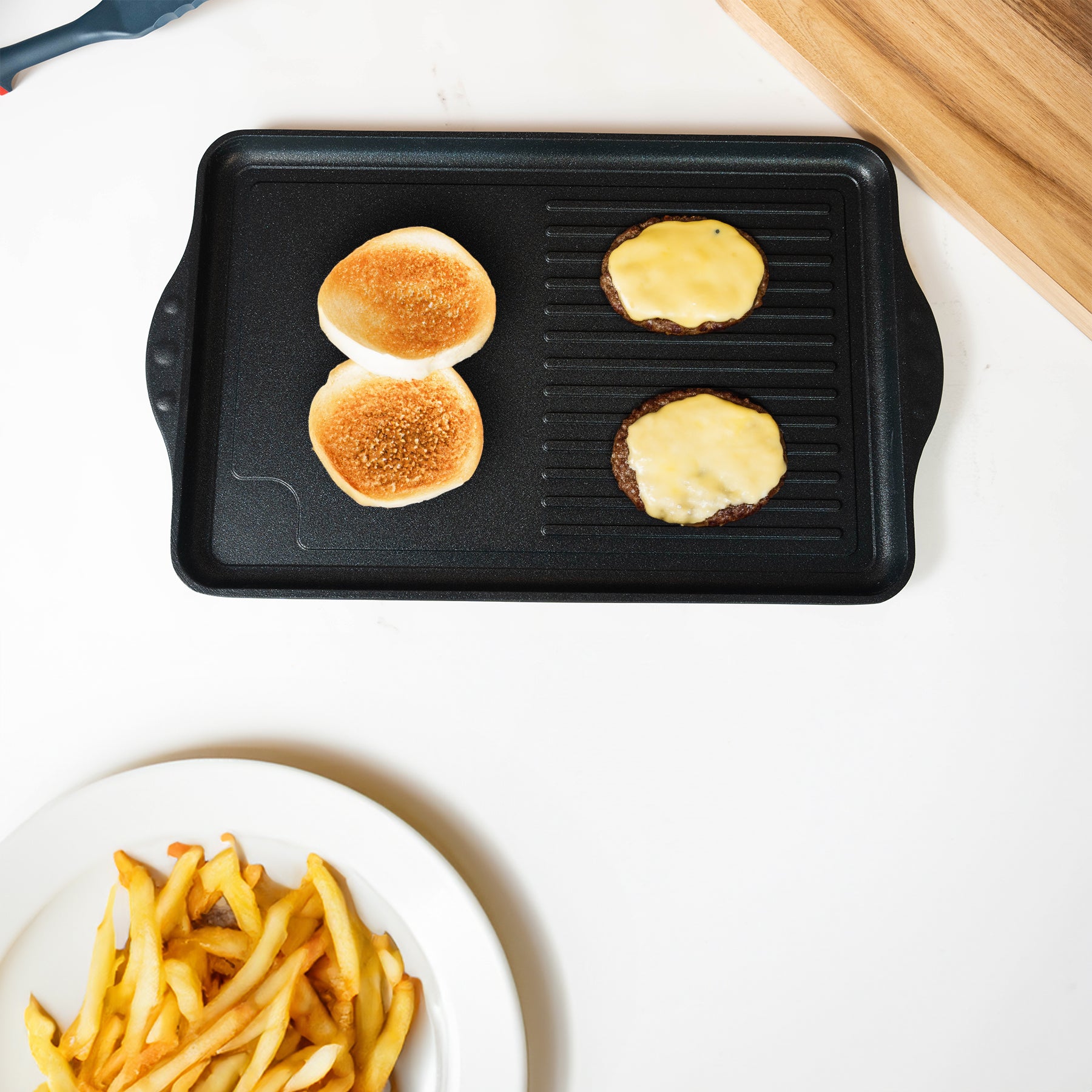 XD Nonstick 17" x 11" Double-Burner Grill/Griddle Combo in use with food on pan