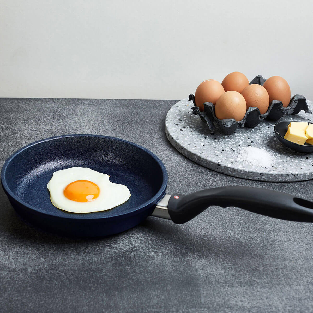 fry pan in use with sunny side up egg on kitchen counter