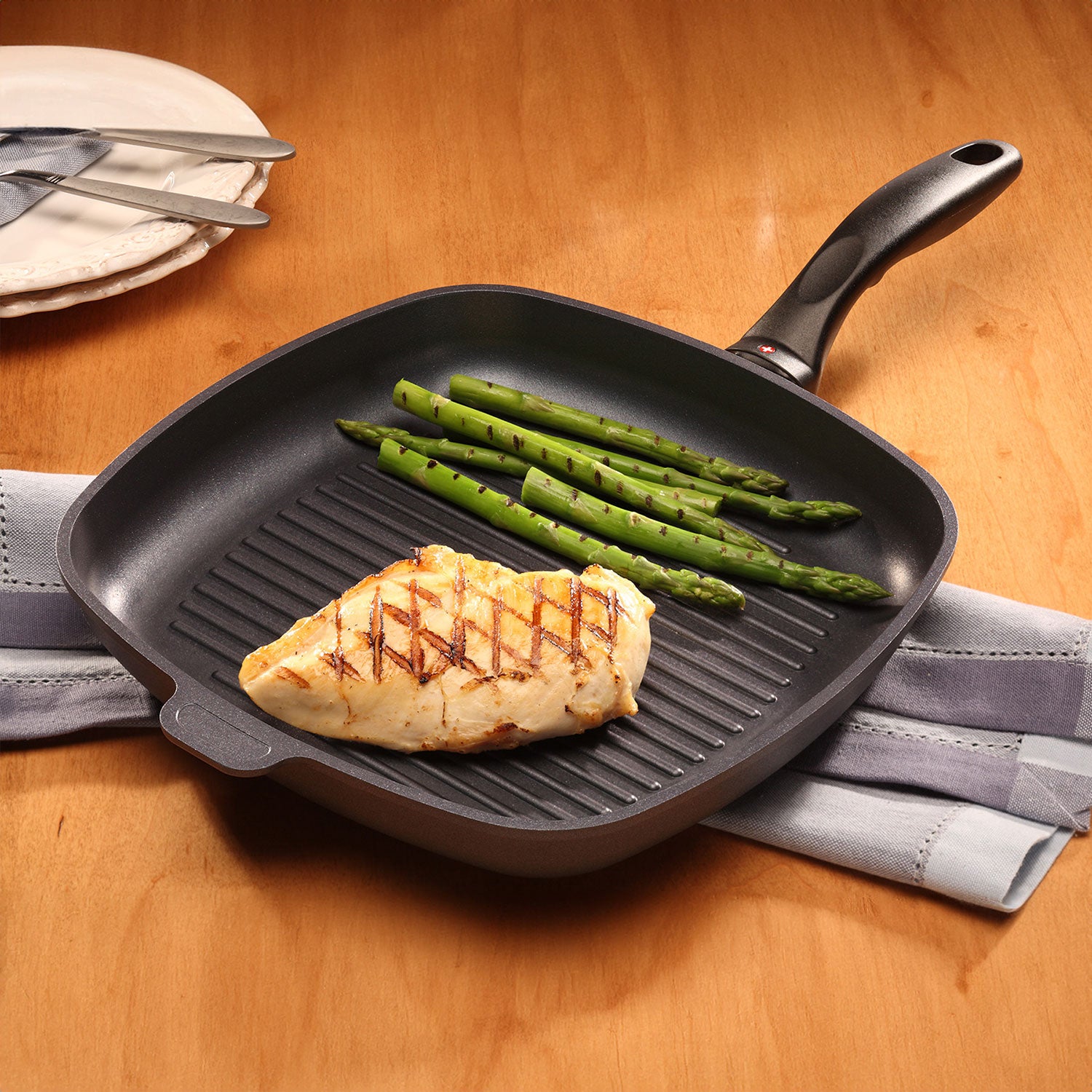 hd induction square grill pan with food on it sitting on wooden table