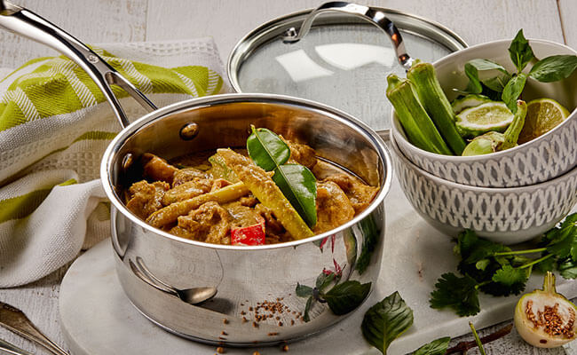 dlx saucepan on wooden table with food inside