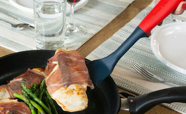 fry pan with food inside and being lifted out with spatula 